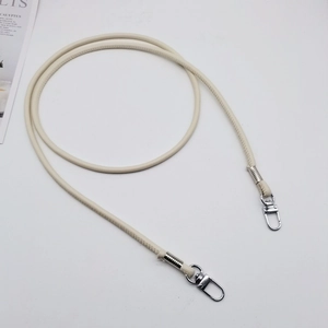 Detail of cream PU leather bag strap featuring silver swivel hooks and fine stitching