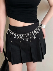 Detail of layered waist chain with white pearls and silver star and shell pendants