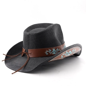 Detail of black straw cowboy hat featuring brown leather band with blue floral embroidery