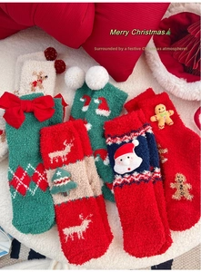 Détail de chaussettes de Noël douillettes avec décorations festives de rennes et Père Noël