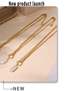 Detailed macro view of 18k gold double-layered necklace with baroque pearl pendant