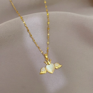 Close-up of golden angel heart necklace with crown detail and shimmering stones