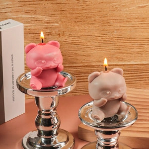 Candele profumate a forma di panda in rosa e grigio su eleganti basi in metallo