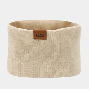 Close-up of beige ribbed knit neck warmer with brown leather patch featuring MOM text
