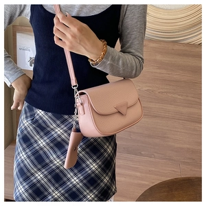 Détail du sac à bandoulière rose poudré avec texture litchi et mini porte-monnaie