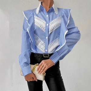Detail of blue striped shirt with white lace patchwork and elegant ruffle shoulders