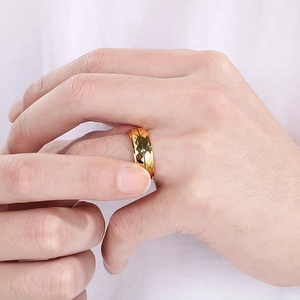 Detailed view of men's golden geometric diamond cut ring with polished facets on a hand
