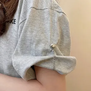 Gray T-shirt sleeve with silver magnetic chain clip for shortening and folding hems