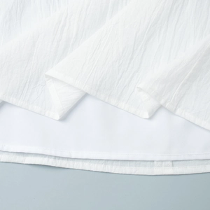 Detail of white textured fabric with neat double-needle stitching on the hemline