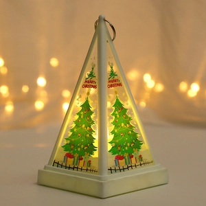 Detail of Christmas lantern with glowing LED tree patterns and golden pyramid frame