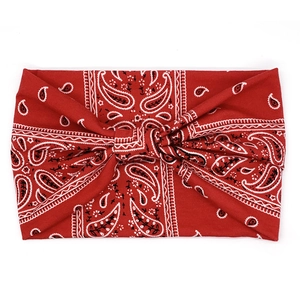 Detail of red paisley wide knotted headband with classic bohemian pattern on white surface