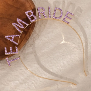 Detail of gold metal headband featuring Team Bride text in purple rhinestones