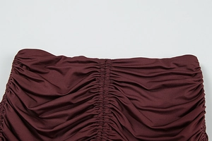 Detailed macro view of dark red ruched fabric texture with elastic shirring design