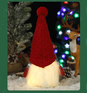 Dettaglio di uno gnomo natalizio luminoso con cappello rosso a maglia e barba a LED caldi