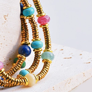 Detailed macro view of colorful natural stone beads and golden metal spacers on bracelet