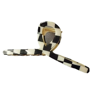 Checkered geometric hair claw clip with black and white patterns and gold metal spring