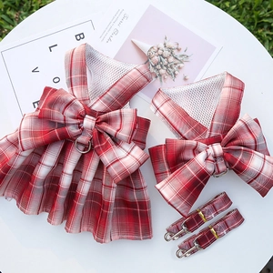Detail of red plaid pet harness dress with bow decoration and matching leash set