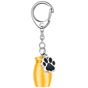 Detail of yellow cylinder pet cremation urn keychain with silver ring and paw print charm