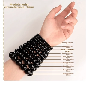 Size comparison of natural black crystal beads from 4mm to 20mm on a model's wrist
