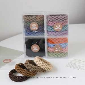 Close-up of elastic checkered hair ties in assorted colors and clear storage boxes