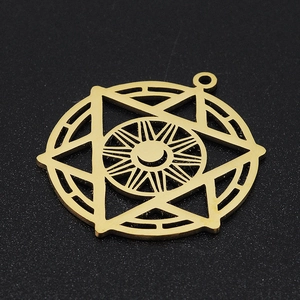 Macro detail of a gold stainless steel celestial pendant with sun and moon motifs