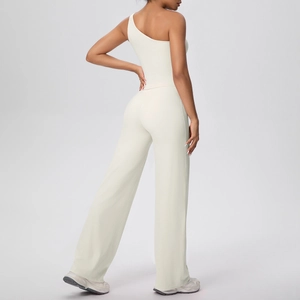 Détail du pantalon de yoga à jambes larges et du haut asymétrique à une épaule en crème