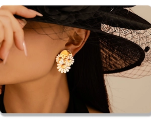 Detailed view of 18k gold daisy earrings on a model with vintage black lace veil accessory