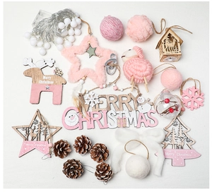 Flat lay of pink and white wooden Christmas ornaments with LED lights and plush elk