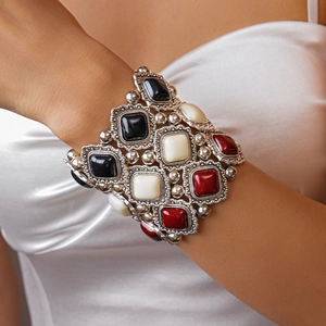 Close-up of retro silver bangle with black white and red gemstones on a model wrist