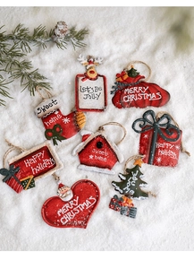 Set of 8 vintage metal Christmas ornaments with festive slogans on artificial snow
