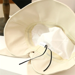 Detail view of cream sun hat interior with adjustable drawstring and smooth lining