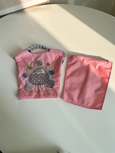 Detailed embroidery of hedgehog and flowers on pink nylon portable storage organizer bag