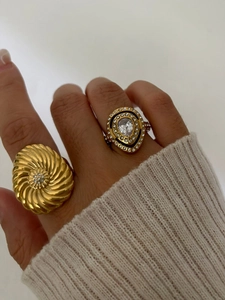 Detailed close-up of a luxury gold double-ring set with crystal flower and pear-shaped stone