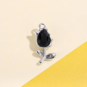 Macro shot of silver tulip pendant with black teardrop gem and top hanging ring loop