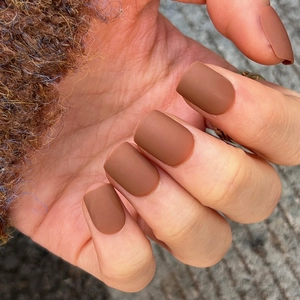 Short matte caramel brown square press on nails shown with a cozy winter sweater