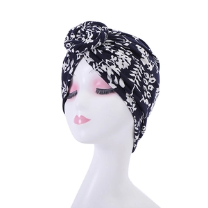 Detail of navy blue turban with white floral print and stylish top knot knot twist