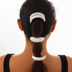 Close-up of three curved silver metal hairpins styled on a ponytail with a double-layer design