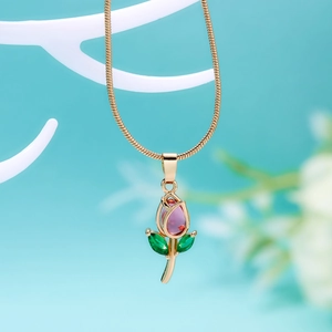 Detailed close-up of a gold tulip necklace with pink and green gemstones on a branch