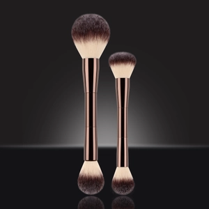 Dual-ended makeup brush set with bronze metal handles and gradient bristles on dark background