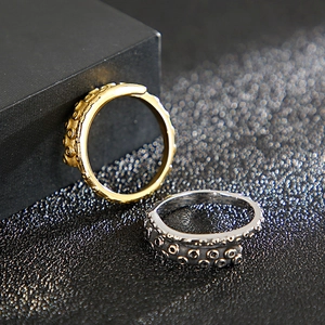 Macro shot of octopus tentacle rings showing detailed suction cups in gold and silver finish
