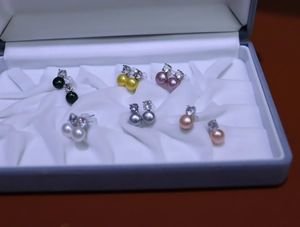 Close-up of elegant multicolor freshwater pearl earrings set in a velvet jewelry box