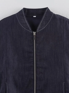 Close-up of a dark blue denim bomber jacket showing silver zipper and baseball collar details