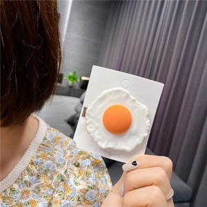 Detail of creative poached egg hair clip showing realistic food texture on card