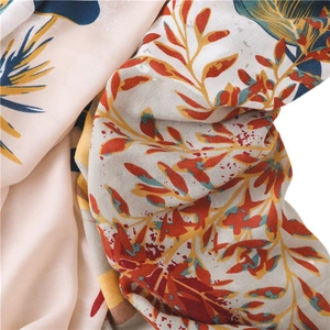 Linen cotton scarf featuring vibrant autumn leaf patterns in red and blue hues