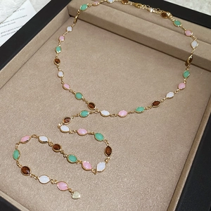 Detailed top view of a gold resin tassel Y-necklace set in a premium beige velvet box