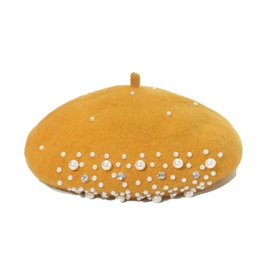Detail of ginger wool beret featuring elegant white faux pearls and sparkling rhinestones