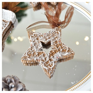 Close-up of star-shaped resin gingerbread ornament with white icing on a mirror tray