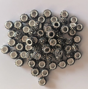Macro shot of 7x12mm black clay beads with inset crystals and silver metal eyelet core