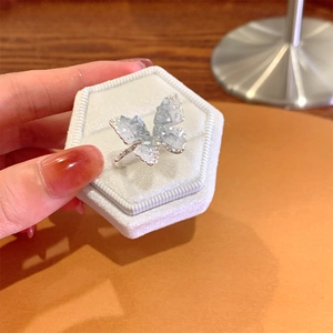 Detail of a silver butterfly ring with light blue crystals in a velvet jewelry box