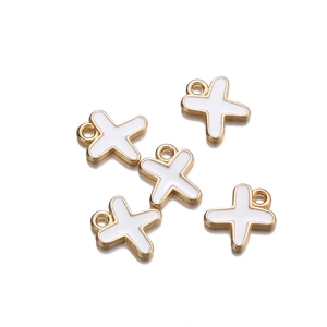 Detailed view of white enamel and gold alloy cross pendants for DIY jewelry making
